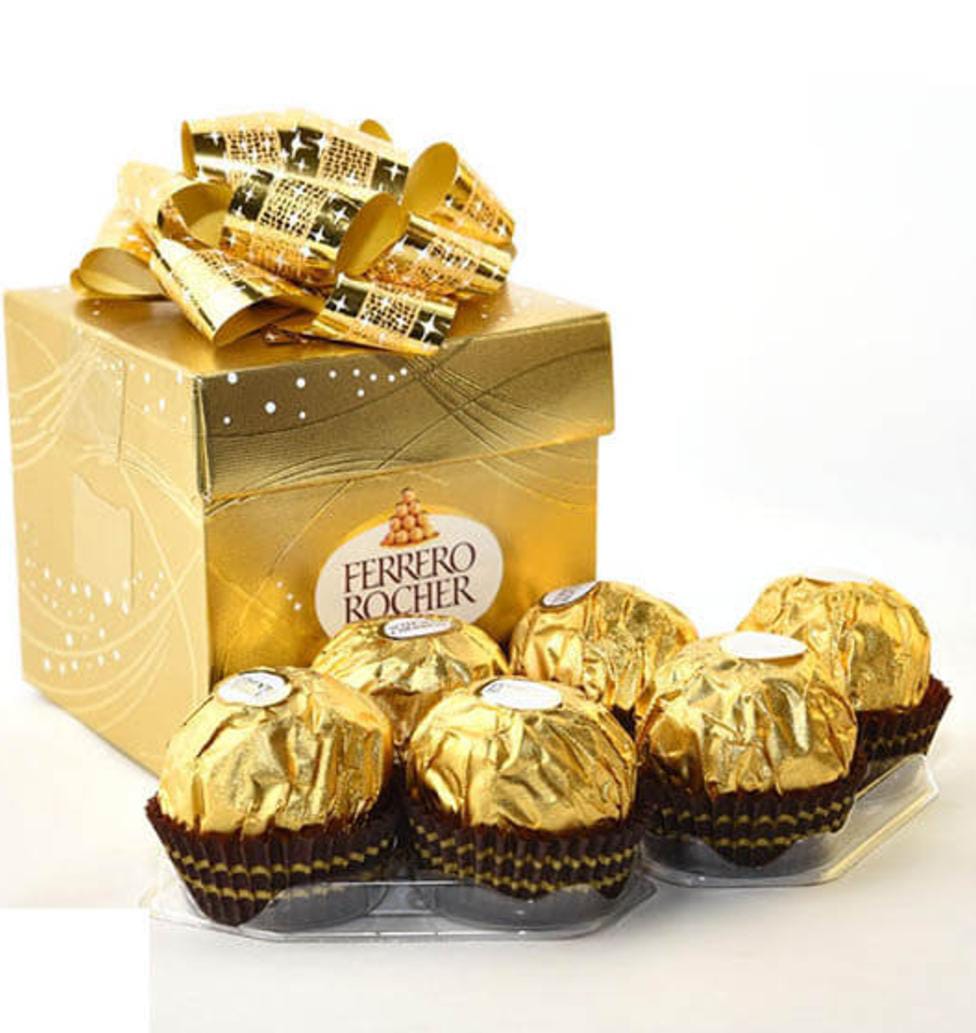 קופסת מתנה זהובה עם שוקולד פררו רושה עטוף בנייר זהב.