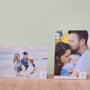 שתי תמונות משפחתיות מודפסות על עץ: אחת של משפחה על חוף הים, והשנייה של זוג מנשק תינוקת.