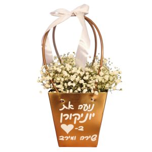 זר פרחי גבסנית לבנים בתוך סלסלת מתכת זהובה עם ידיות, סרט לבן וכיתוב בעברית.
