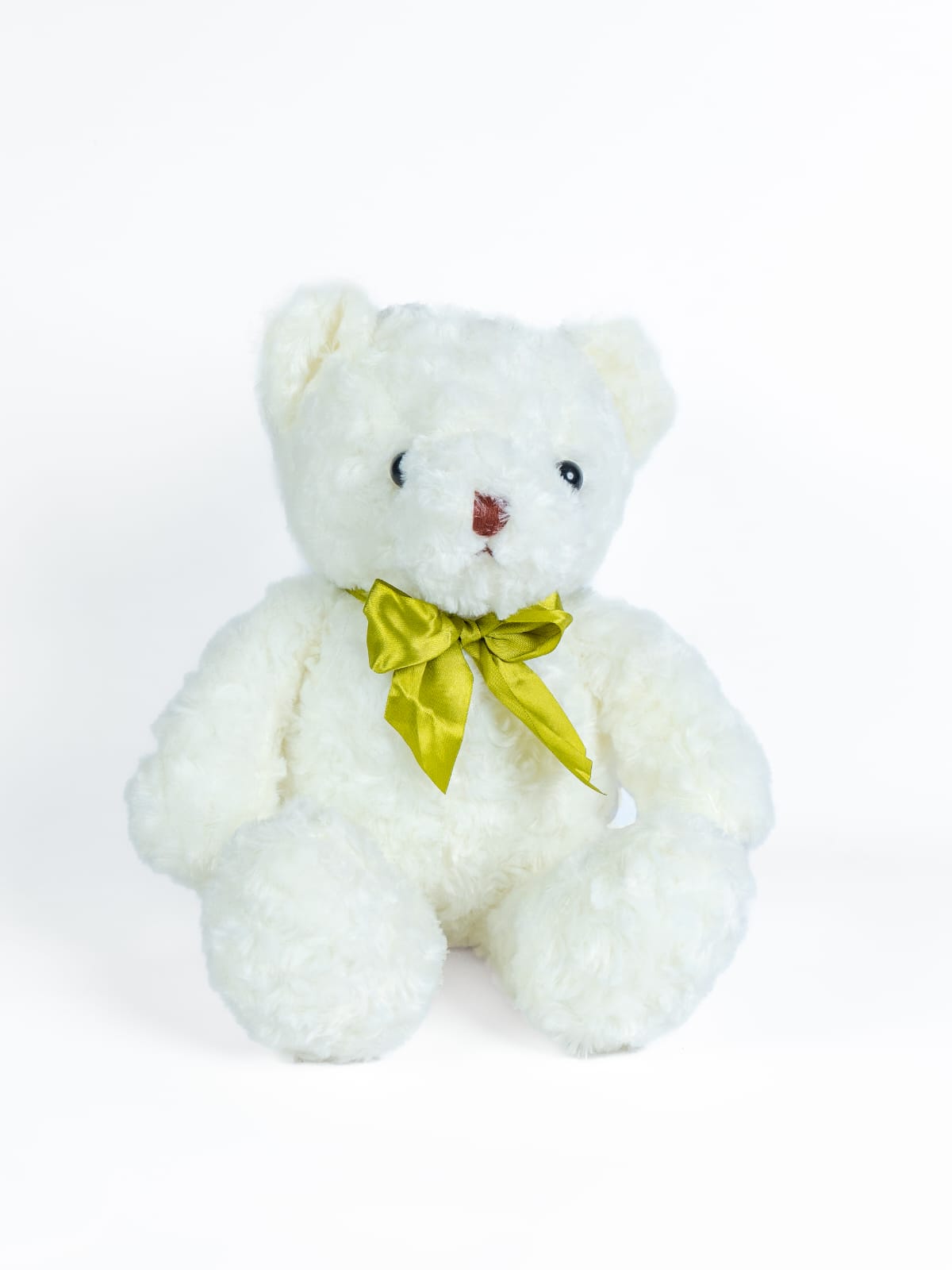 בובה של דוב לבן יושבת עם סרט ירוק סביב צווארה.