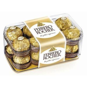 קופסת פלסטיק שקופה מלאה בשוקולדים עטופים בנייר זהב של פררו רושה, עם סרט זהב עליהם.