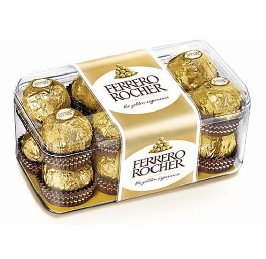 קופסת פלסטיק שקופה מלאה בשוקולדים עטופים בנייר זהב של פררו רושה, עם סרט זהב עליהם.