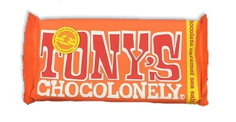 בתמונה מופיע שוקולד טוניס שוקולונילי בטעם קרמל ומלח ים, עטוף בנייר כתום.