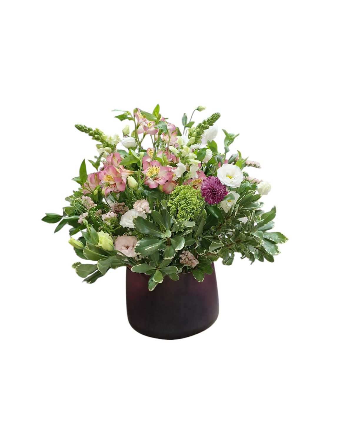 זֵר פרחים גדול וצבעוני, הכולל פרחים לבנים, ורודים וסגולים, עומד בתוך עציץ סגלגל כהה.