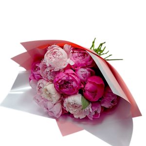 זֵר פְּיוֹנִים ורודים וורודים עמוקים עטוף בנייר ורוד בהיר.