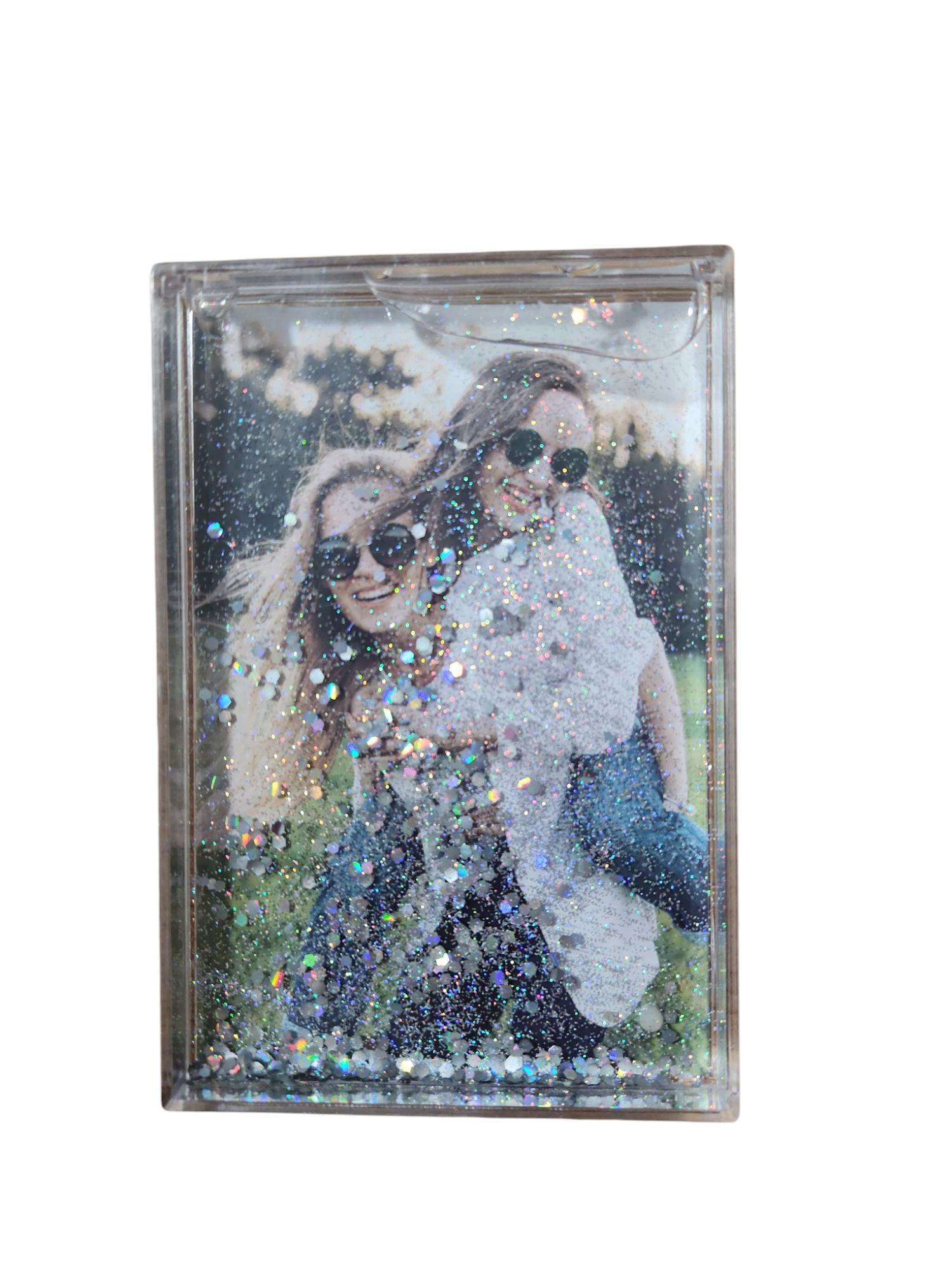 תמונה בתוך מסגרת נוזלית עם נצנצים: שתי נשים צעירות מחייכות, אחת נושאת את השנייה על גבה.