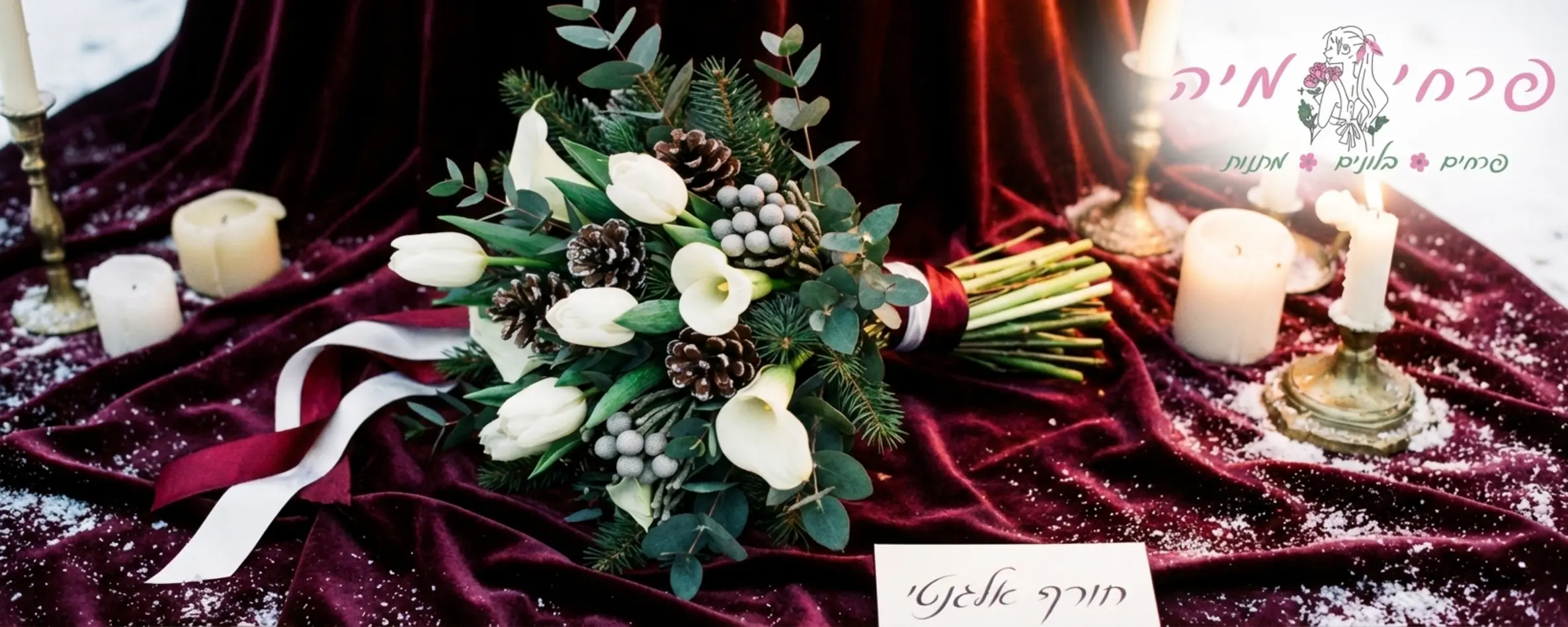 זר כלה חורפי ואלגנטי הכולל שילוב של טוליפים לבנים, קאלות עדינות וירק חורפי כהה, מונח על גבי רקע של בד קטיפה בצבע בורדו עמוק המעביר תחושה של חורף יוקרתי