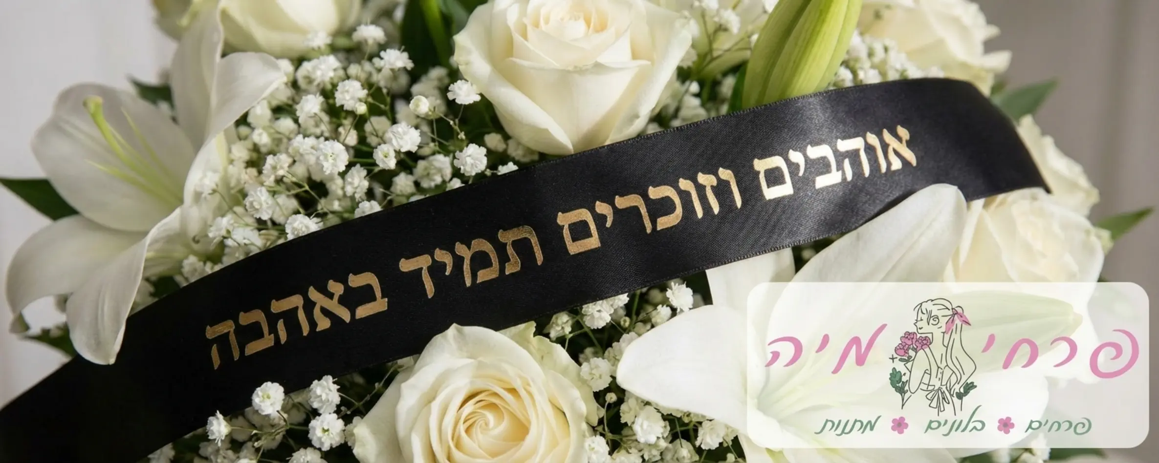 צילום תקריב איכותי של סרט שחור אלגנטי המשולב בתוך זר פרחים לבנים ועליו מודפס באותיות זהב בוהקות הכיתוב אוהבים וזוכרים תמיד באהבה