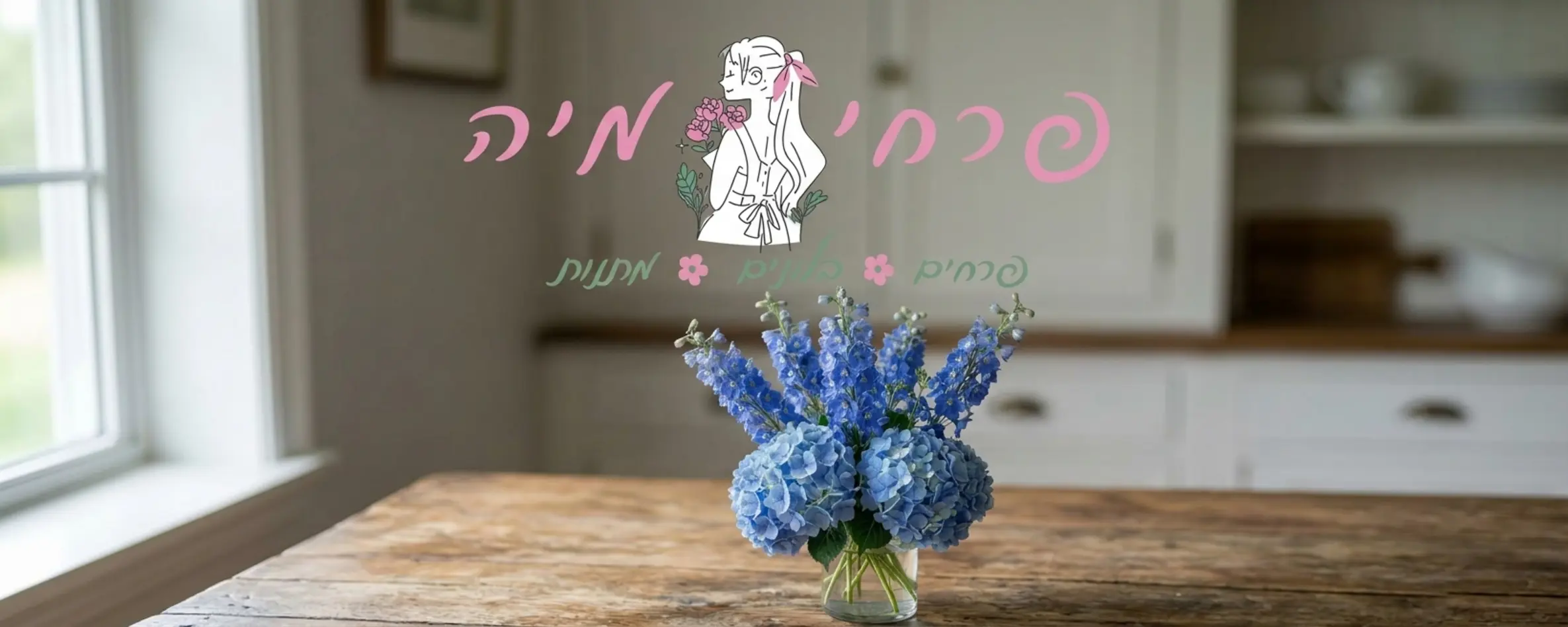 תקריב איכותי של זר המשלב פרחי דלפיניום גבוהים והידראנג'אה כחולה באגרטל זכוכית שקוף המונח על שולחן עץ כפרי